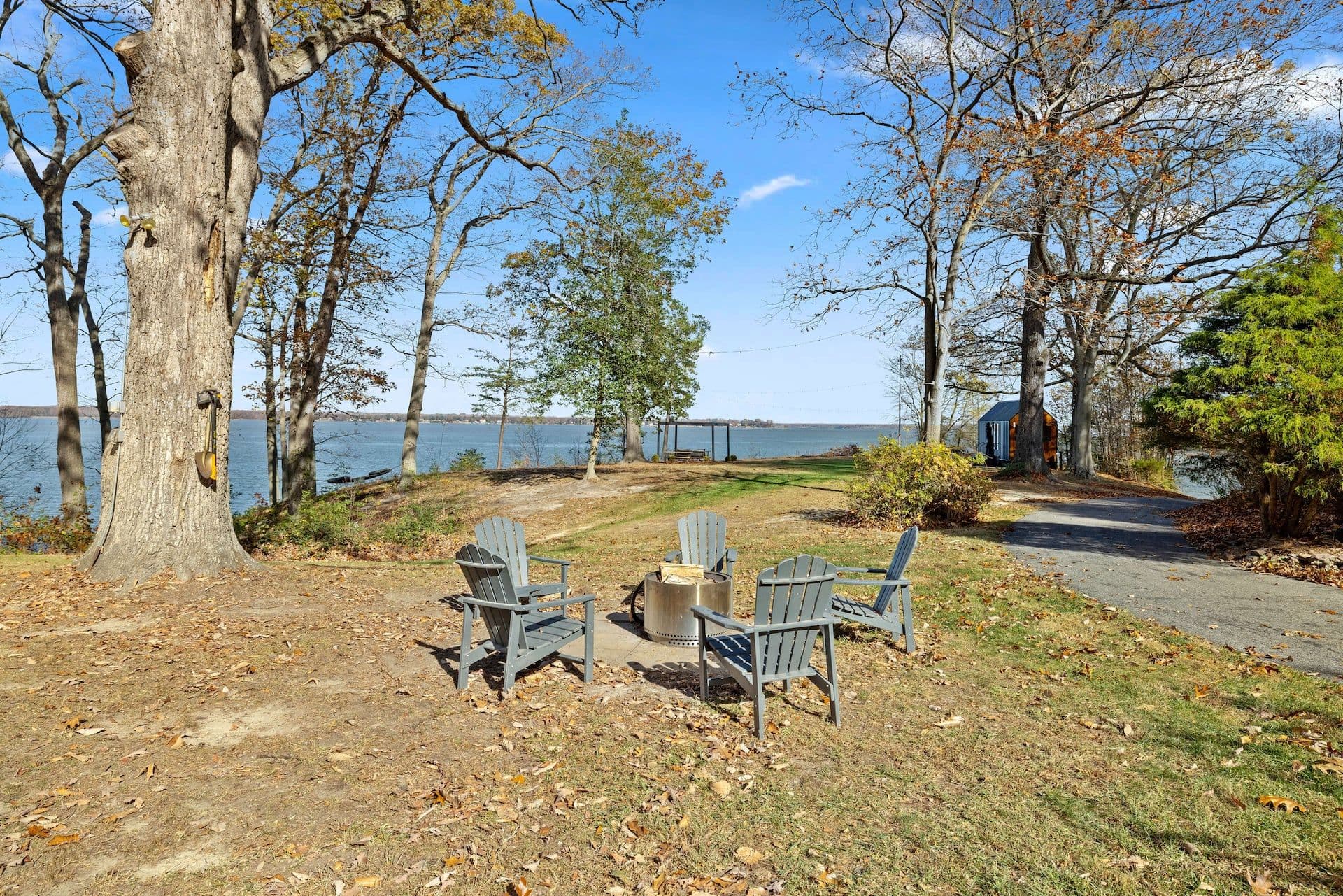 Adirondack chairs around the fire pit with the river beyond